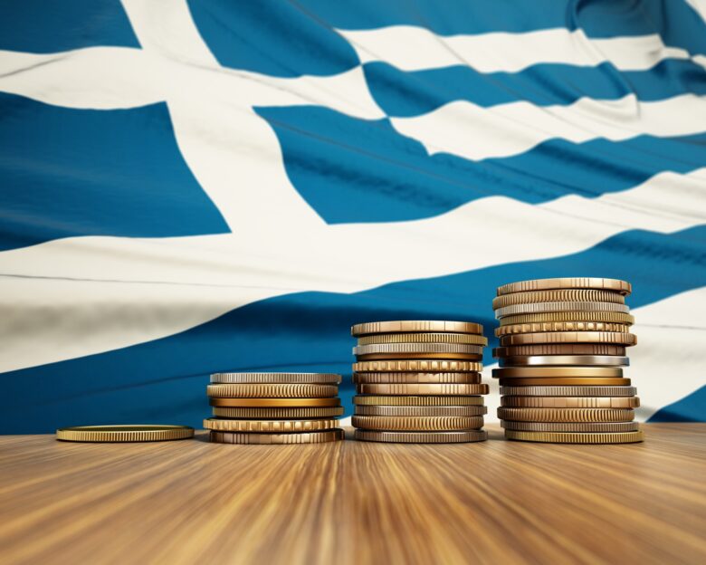 Rising stack of coins with Greek flag in the background. Economy, finance, interest rates concept.