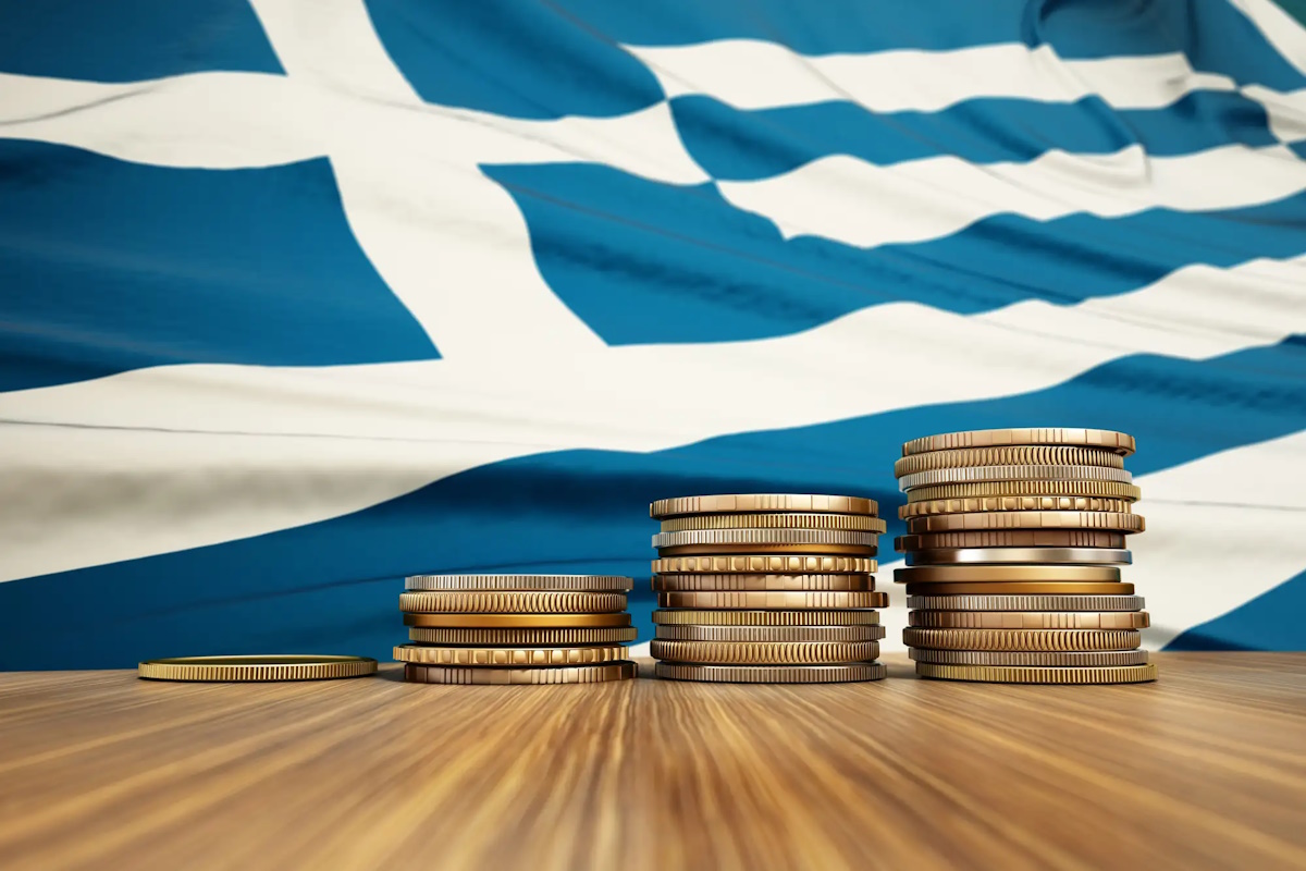 Rising stack of coins with Greek flag in the background. Economy, finance, interest rates concept.
