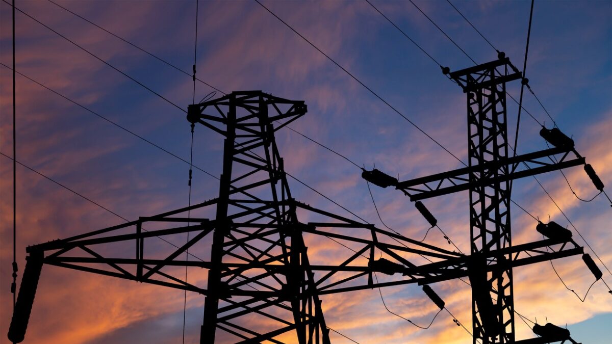 Electricity pylon (high voltage power line), black contour, against the background of a romantic evening sky