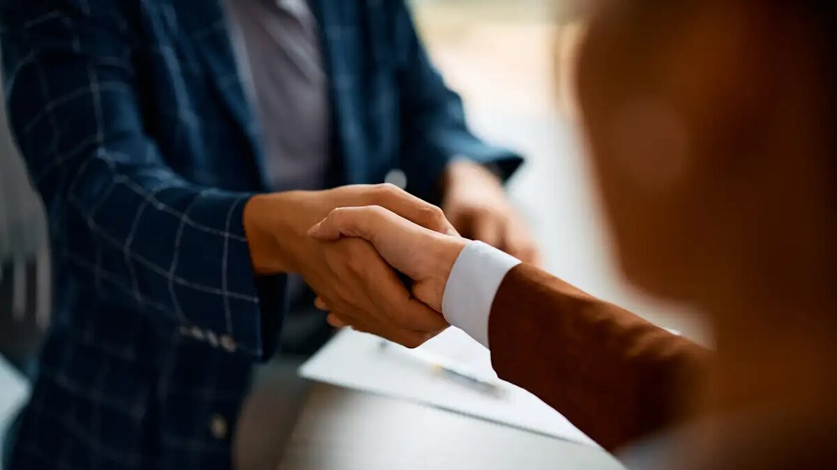 Close up of coworkers handshaking while greeting during business meeting in the office