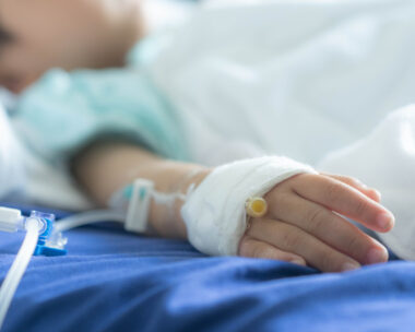 an Asian todler in hospital with intravenous saline. Sick children, infected with the virus, are lying and being treated in beds in hospitals.