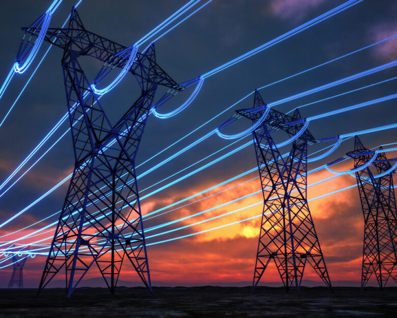Steel electricity transmission towers stretch across the horizon at sunset, with digitally enhanced glowing blue lines representing energy flow through the power grid.