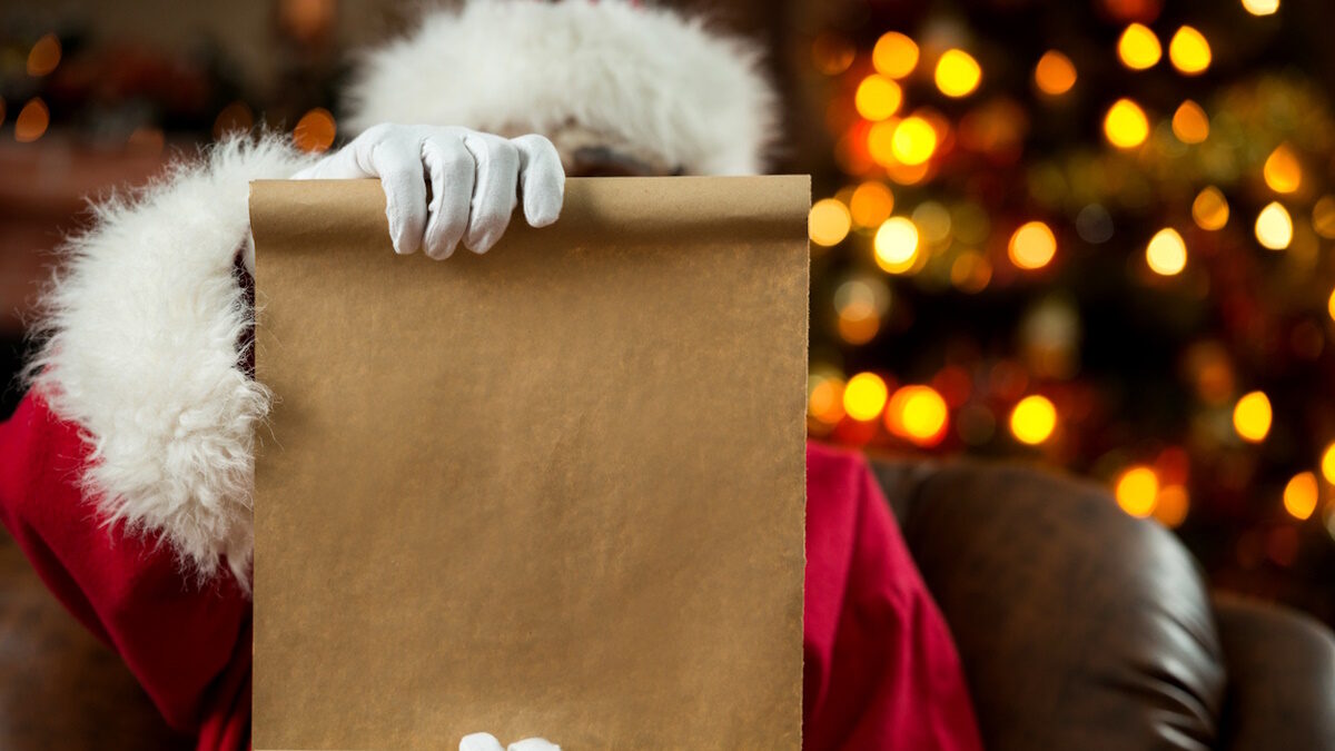 St. Nicholas sitting in armchair at home and showing blank paper. Focus is on