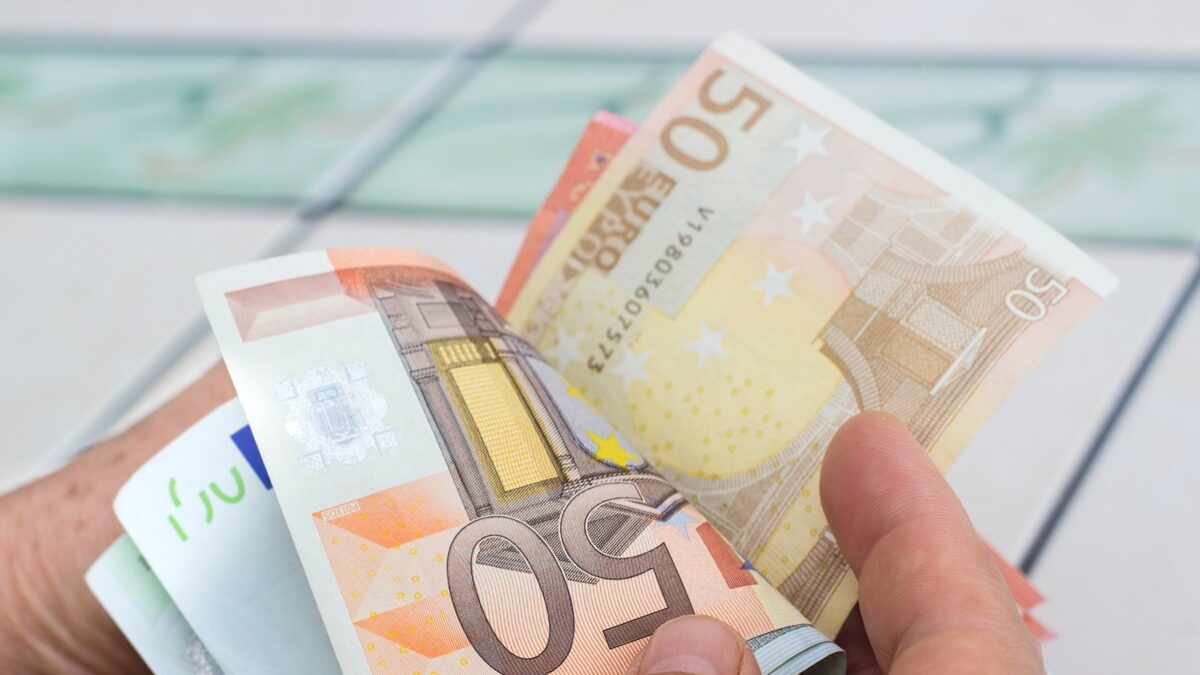 Close-up view of unrecognizable man counting money. Horizontal composition. Studio shot. Image developed from RAW format