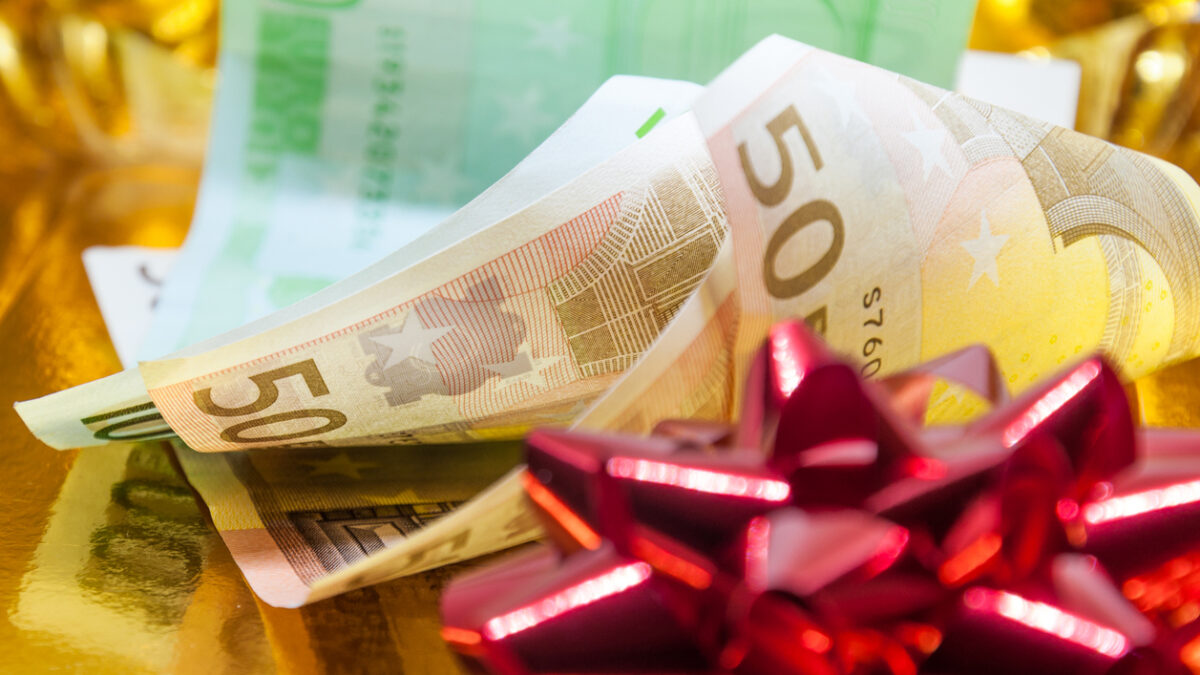 Money with a red gift bow on golden background