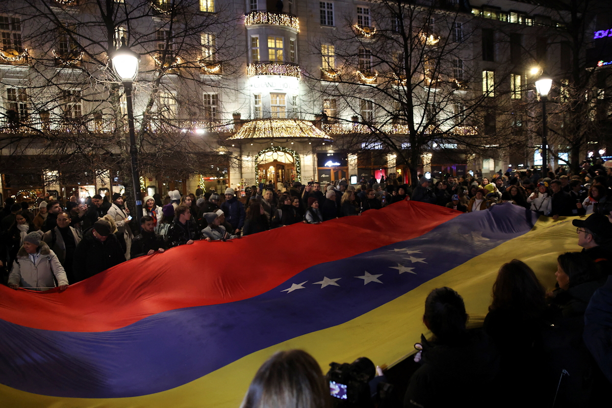 Άνθρωποι κρατούν μια μεγάλη εθνική σημαία της Βενεζουέλας κατά τη διάρκεια πομπής με φακούς για να τιμήσουν τη φετινή νικήτρια του Νόμπελ Ειρήνης, την ηγέτιδα της αντιπολίτευσης της Βενεζουέλας Μαρία Κορίνα Ματσάντο, στο Όσλο
