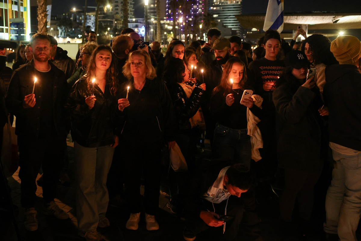 Άνθρωποι κρατούν κεριά κατά τη διάρκεια αγρυπνίας κοντά σε μια παραλία, μετά από ένα θανατηφόρο πυροβολισμό στην παραλία Bondi του Σίδνεϊ, κατά τη διάρκεια εορτασμών για την εβραϊκή γιορτή του Χανουκά, στο Τελ Αβίβ του Ισραήλ