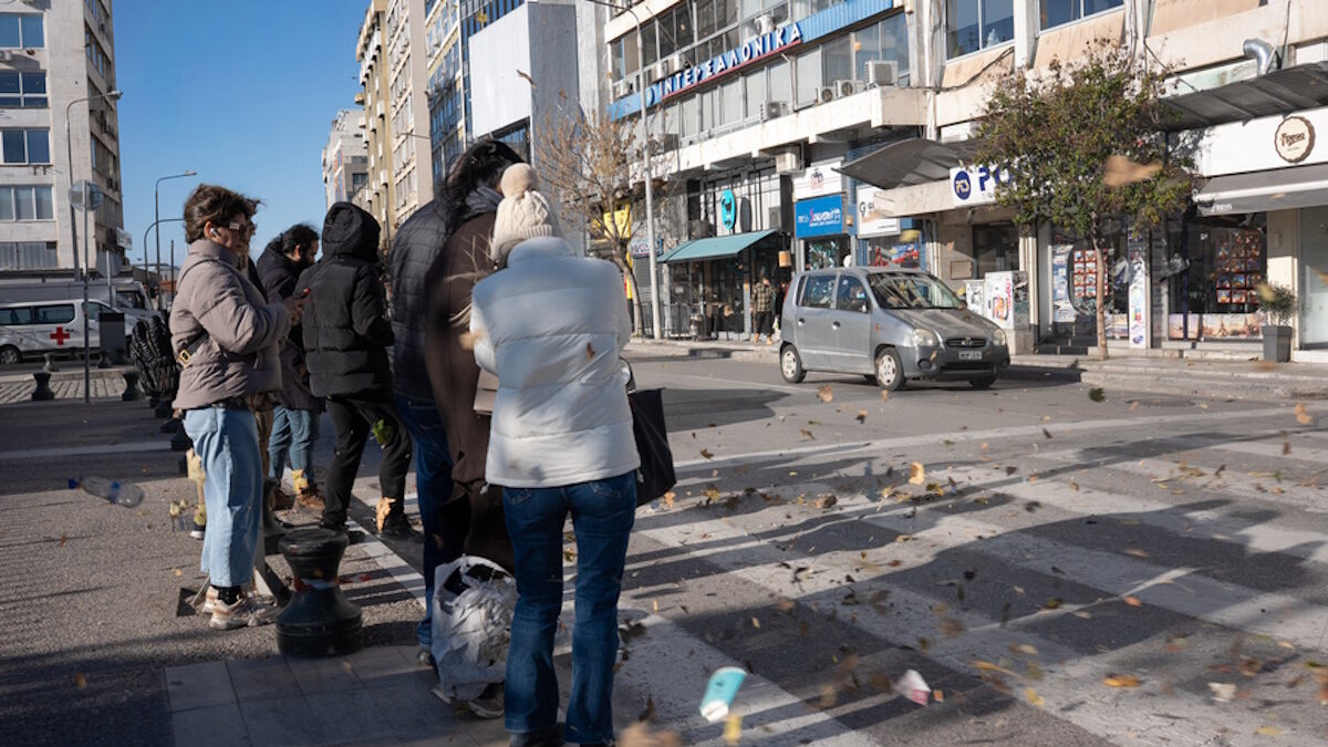 Κόσμος προσπαθεί να προφυλαχθεί από τους δυνατούς ανέμους που πνέουν στη Θεσσαλονίκη την Κυριακή, 28 Δεκεμβρίου