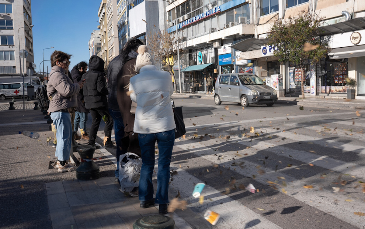 Κόσμος προσπαθεί να προφυλαχθεί από τους δυνατούς ανέμους που πνέουν στη Θεσσαλονίκη την Κυριακή, 28 Δεκεμβρίου
