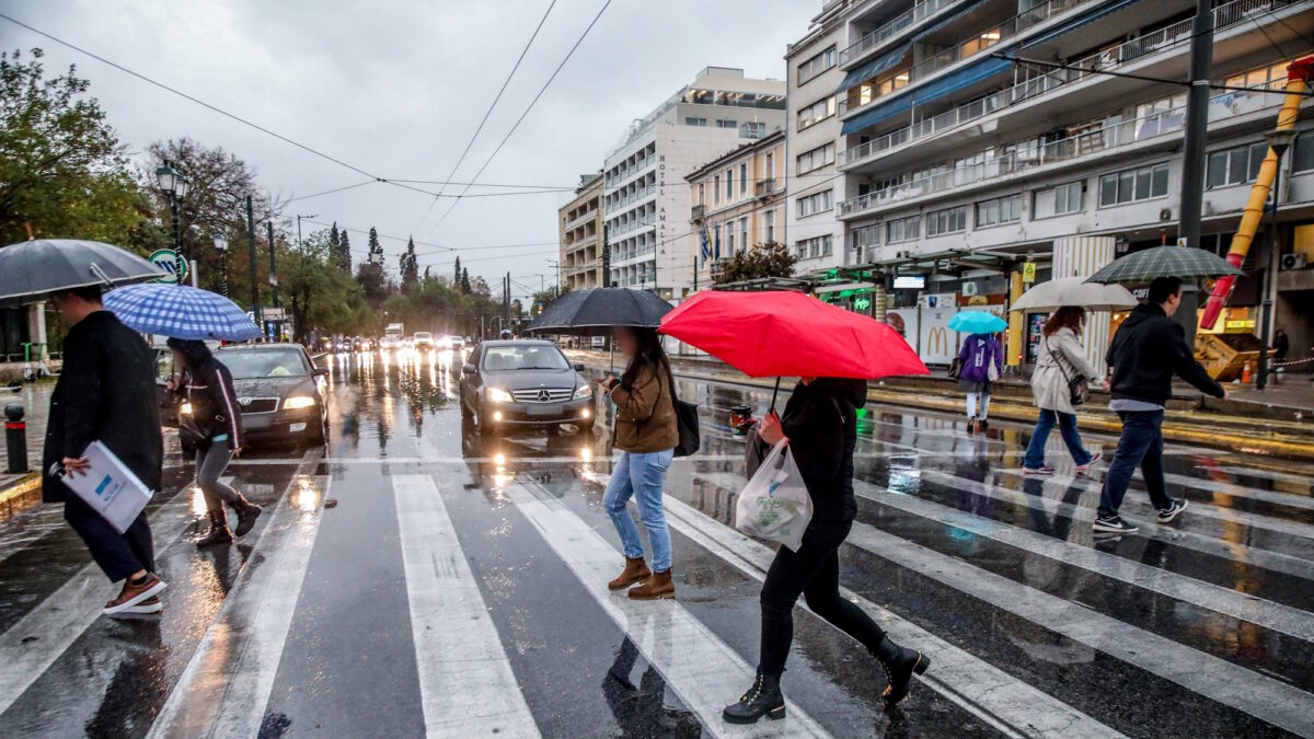 ανθρωποι με ομπρέλες στο κέντρο της Αθήνας