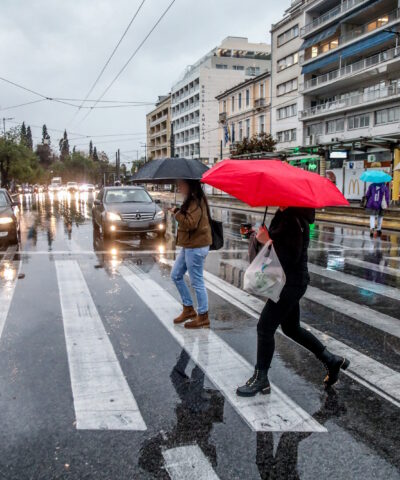 ανθρωποι με ομπρέλες στο κέντρο της Αθήνας