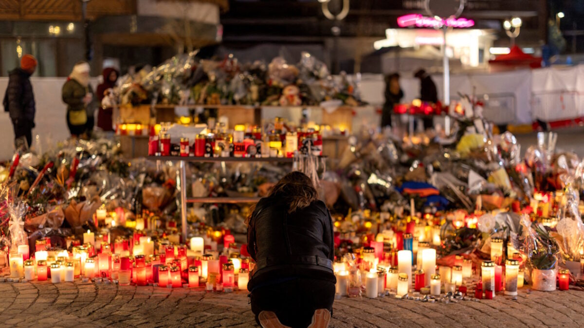 Μια γυναίκα ανάβει ένα κερί σε ένα αυτοσχέδιο μνημείο έξω από το μπαρ «Le Constellation», μετά από μια θανατηφόρα πυρκαγιά και έκρηξη κατά τη διάρκεια ενός πάρτι την παραμονή της Πρωτοχρονιάς, στο πολυτελές χιονοδρομικό κέντρο Crans-Montana στη νοτιοδυτική Ελβετία