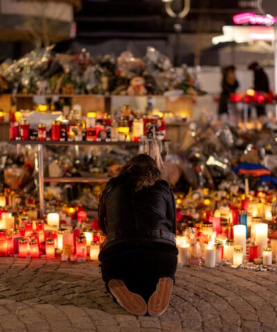 Μια γυναίκα ανάβει ένα κερί σε ένα αυτοσχέδιο μνημείο έξω από το μπαρ «Le Constellation», μετά από μια θανατηφόρα πυρκαγιά και έκρηξη κατά τη διάρκεια ενός πάρτι την παραμονή της Πρωτοχρονιάς, στο πολυτελές χιονοδρομικό κέντρο Crans-Montana στη νοτιοδυτική Ελβετία