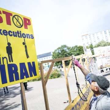 Ταμπέλα με μήνυμα «Σταματήστε τις εκτελέσεις στο Ιράν»