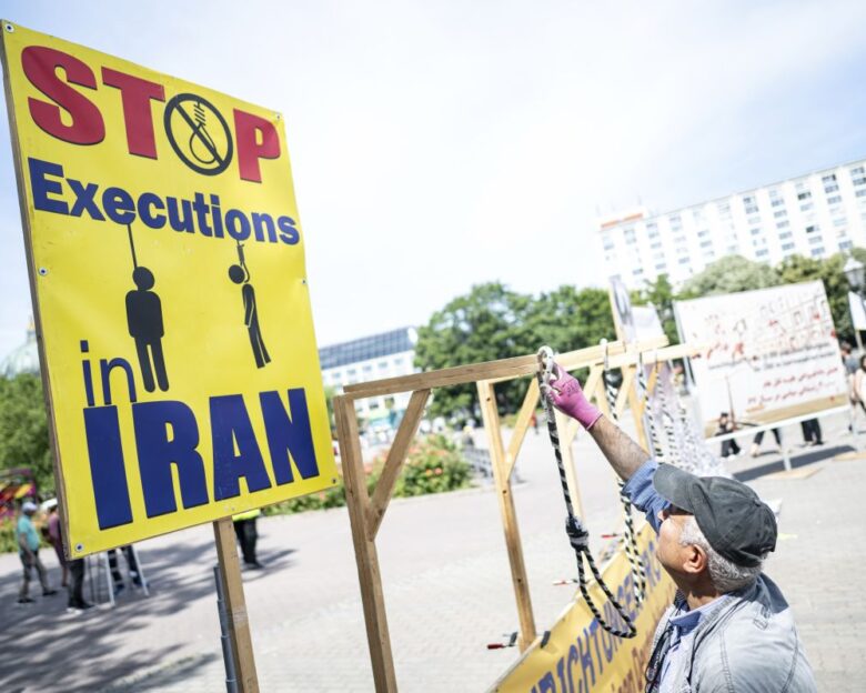 Ταμπέλα με μήνυμα «Σταματήστε τις εκτελέσεις στο Ιράν»