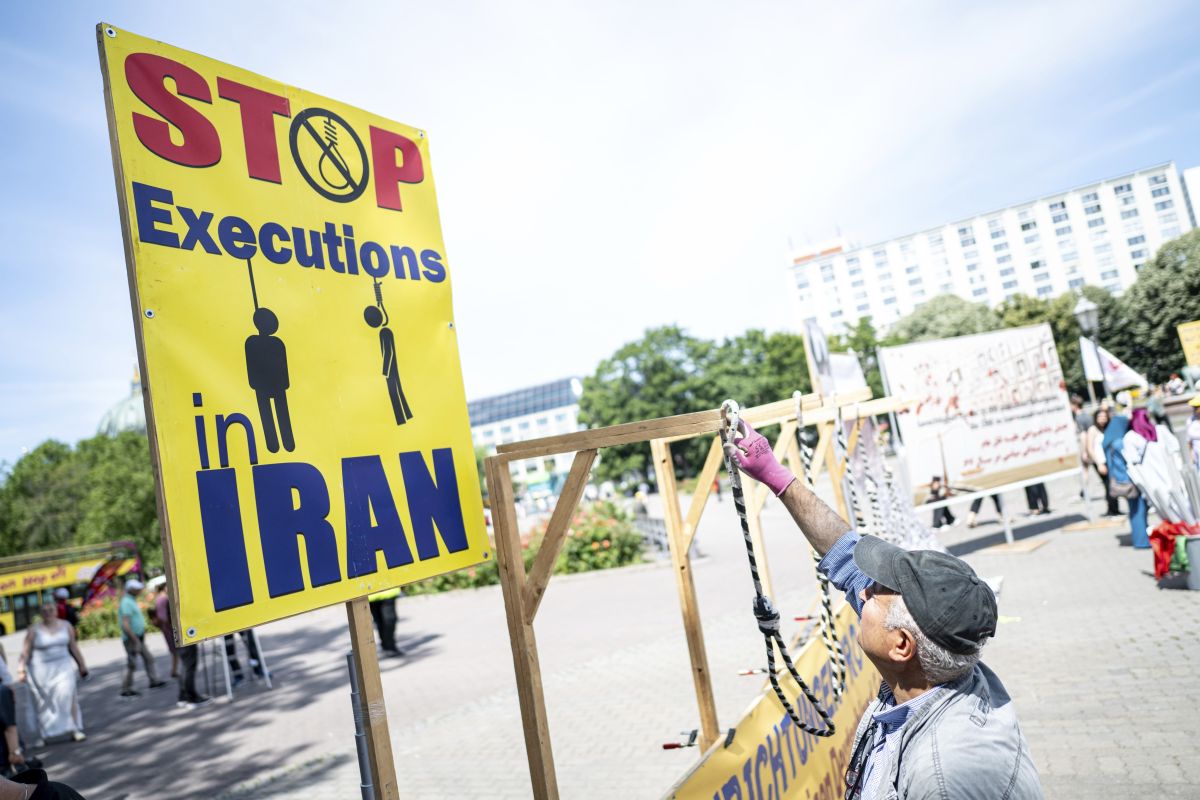 Ταμπέλα με μήνυμα «Σταματήστε τις εκτελέσεις στο Ιράν»