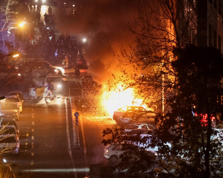 Αυτοκίνητα καίγονται σε δρόμο κατά τη διάρκεια διαμαρτυρίας για την κατάρρευση της αξίας του νομίσματος, στην Τεχεράνη του Ιράν