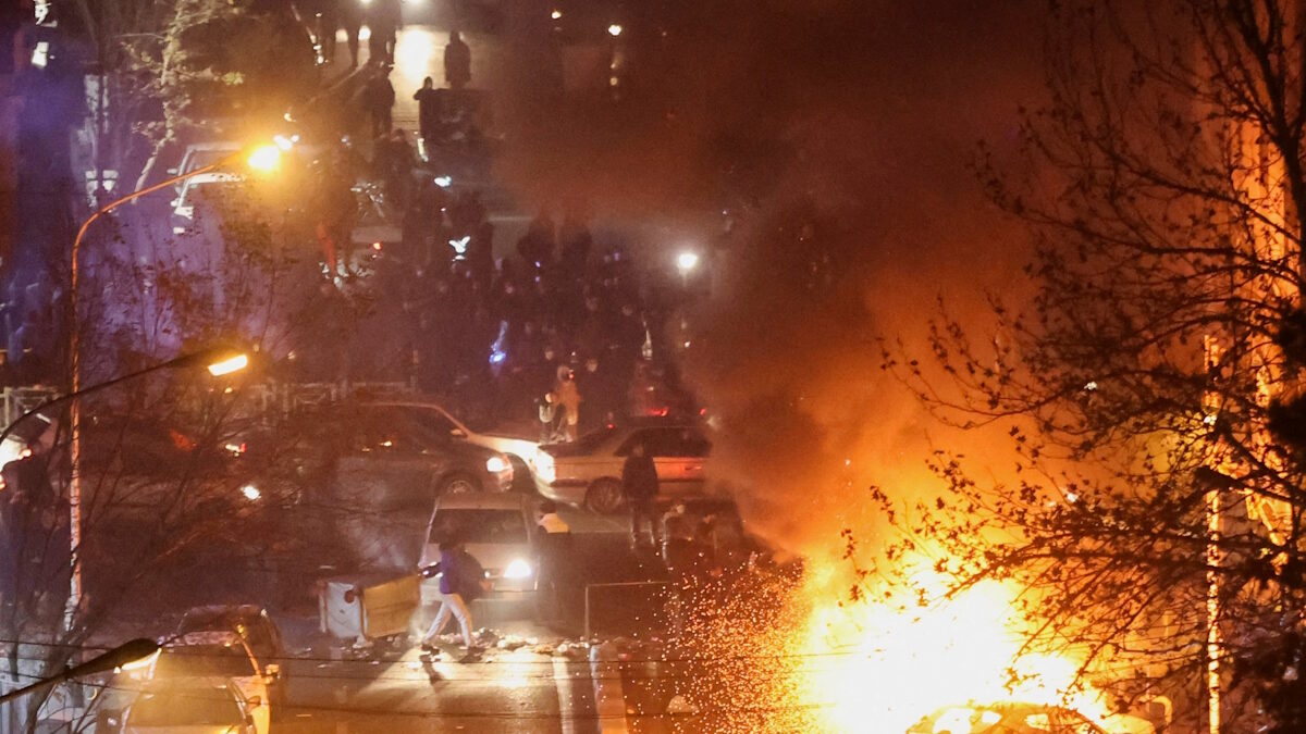 Αυτοκίνητα καίγονται σε δρόμο κατά τη διάρκεια διαδήλωσης για την κατάρρευση της αξίας του νομίσματος, στην Τεχεράνη