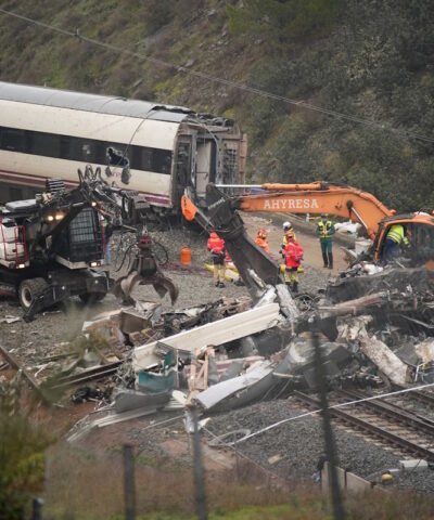 Οι εργάτες χειρίζονται βαριά μηχανήματα καθώς συνεχίζονται οι εργασίες απομάκρυνσης μετά από μια θανατηφόρα εκτροχία δύο τρένων υψηλής ταχύτητας κοντά στο Adamuz