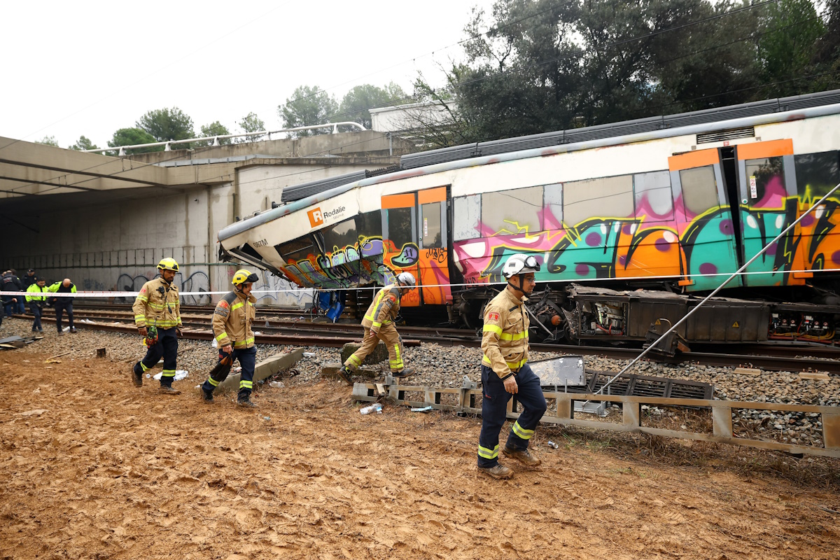 Αστυνομικοί και πυροσβέστες επιθεωρούν τον τόπο του εκτροχιασμού ενός προαστιακού τρένου, μετά την πτώση ενός τοίχου συγκράτησης πάνω στις ράγες λόγω ισχυρών βροχοπτώσεων, με αποτέλεσμα τον θάνατο του οδηγού και τον τραυματισμό αρκετών ατόμων, στη Γελίδα, κοντά στη Βαρκελώνη