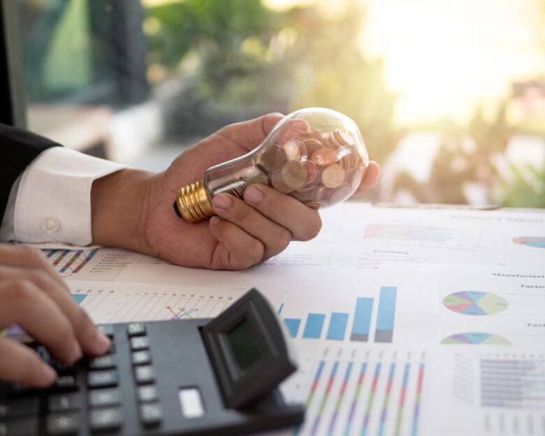 Hand of businessman hold light bulb with coin