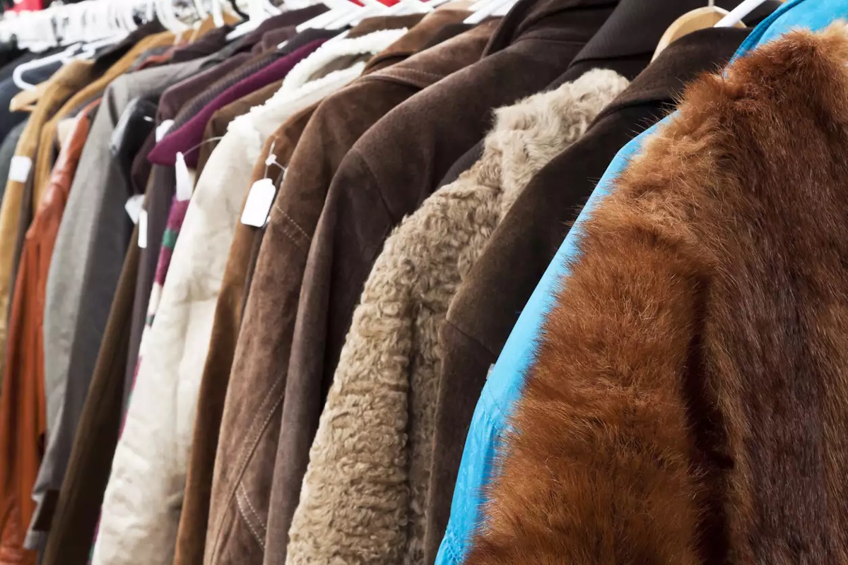 Close up secondhand winter coatsand jackets hanging the shop, full frame horizontal composition