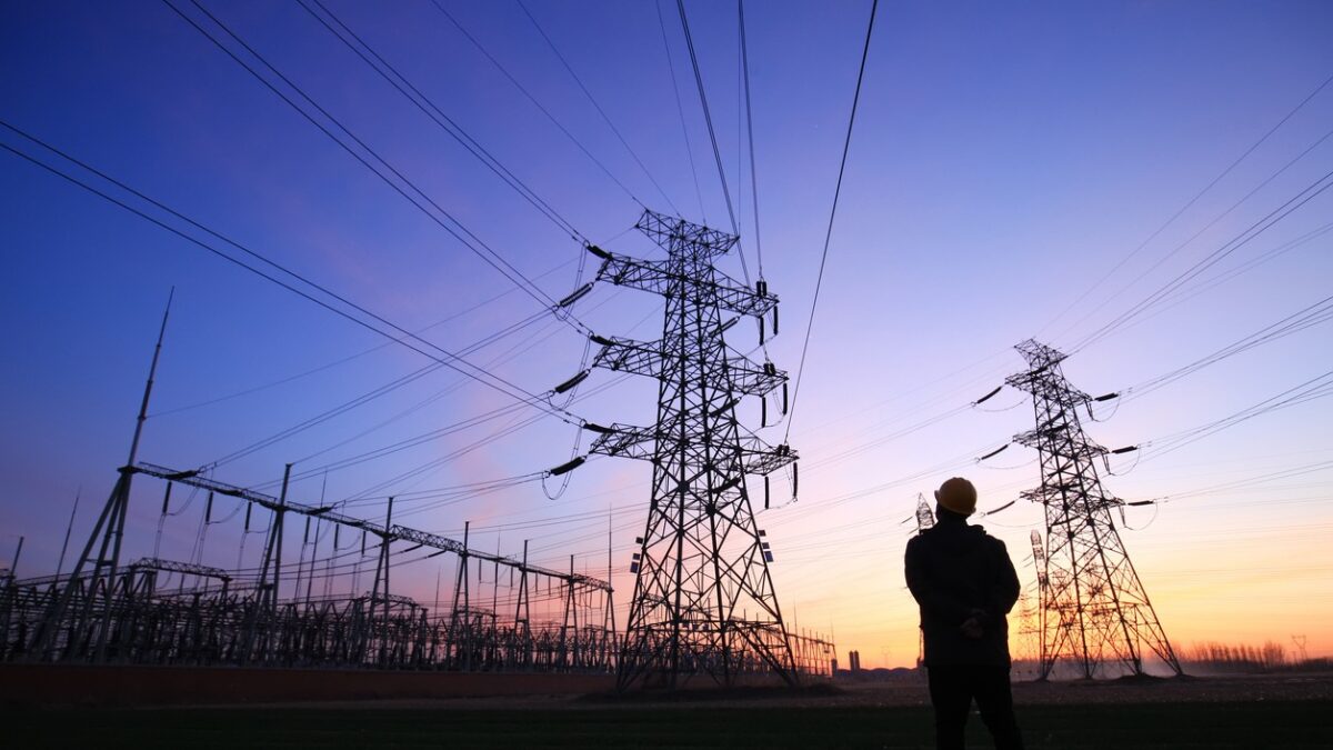 Electricity workers and pylon silhouette