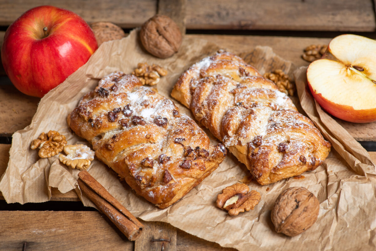 Homemade Apple pie with cinnamon and walnuts on a rustic wooden table