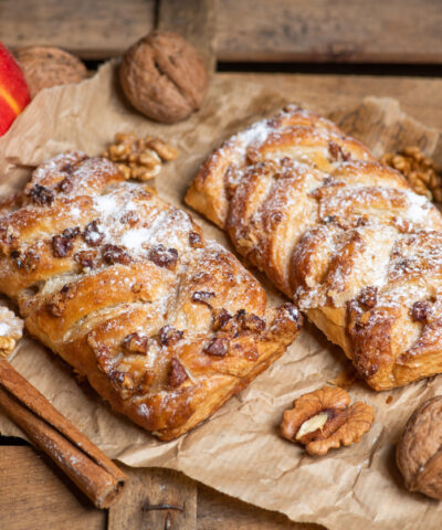 Homemade Apple pie with cinnamon and walnuts on a rustic wooden table