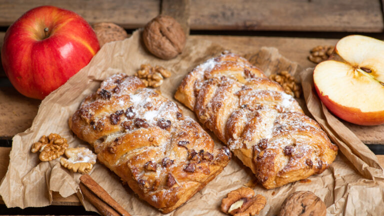 Homemade Apple pie with cinnamon and walnuts on a rustic wooden table