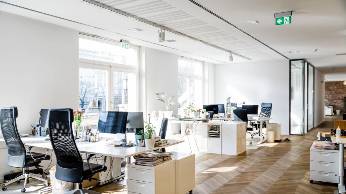 Still life shot of a modern coworking office space. Spacious workplace with desks and computer.