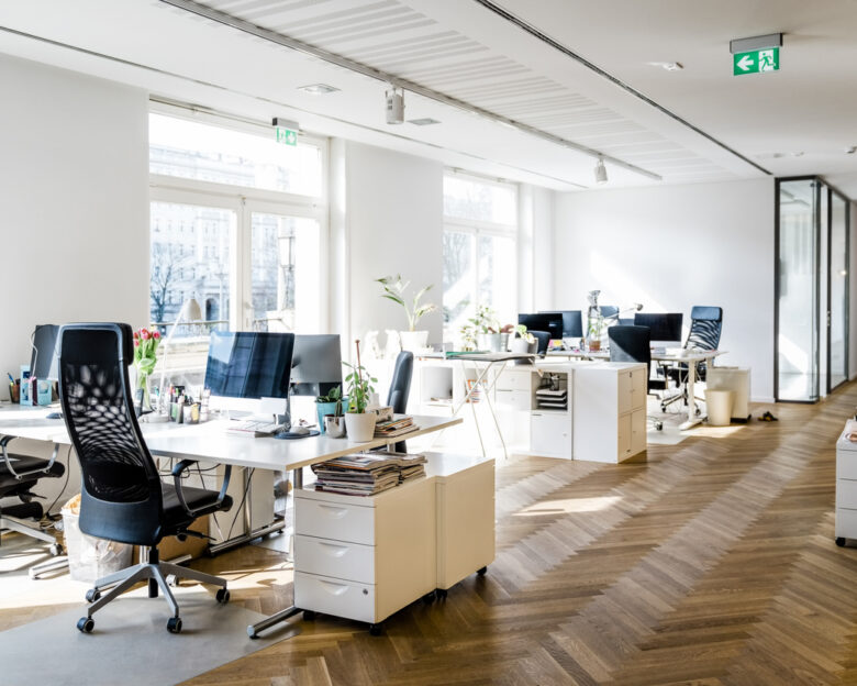 Still life shot of a modern coworking office space. Spacious workplace with desks and computer.
