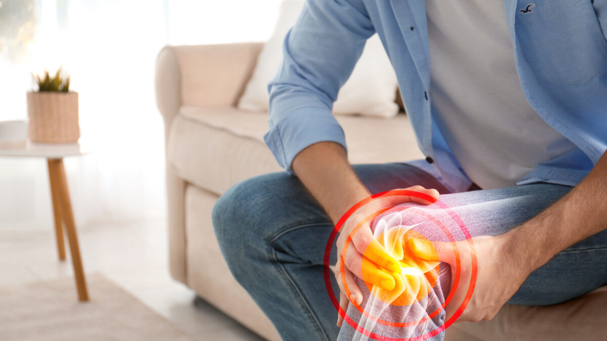 Man suffering from knee pain at home, closeup