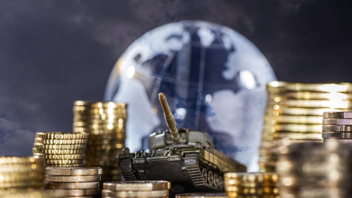 Stacks of money and a tank in front of a globe symbolizing global armament and finance