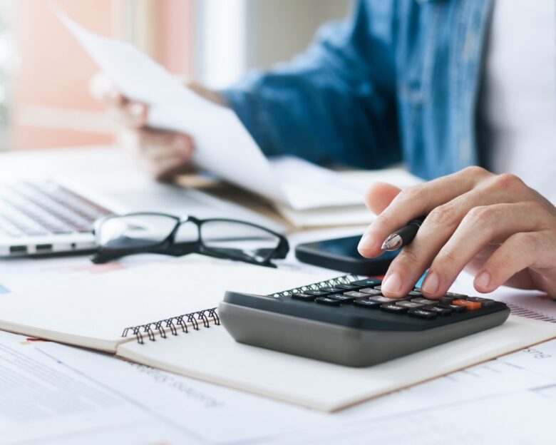 Investors are calculating profits and costs with calculators, growth and investment chart analysis, business planning and strategies to maximize sales profits. Long term business plan