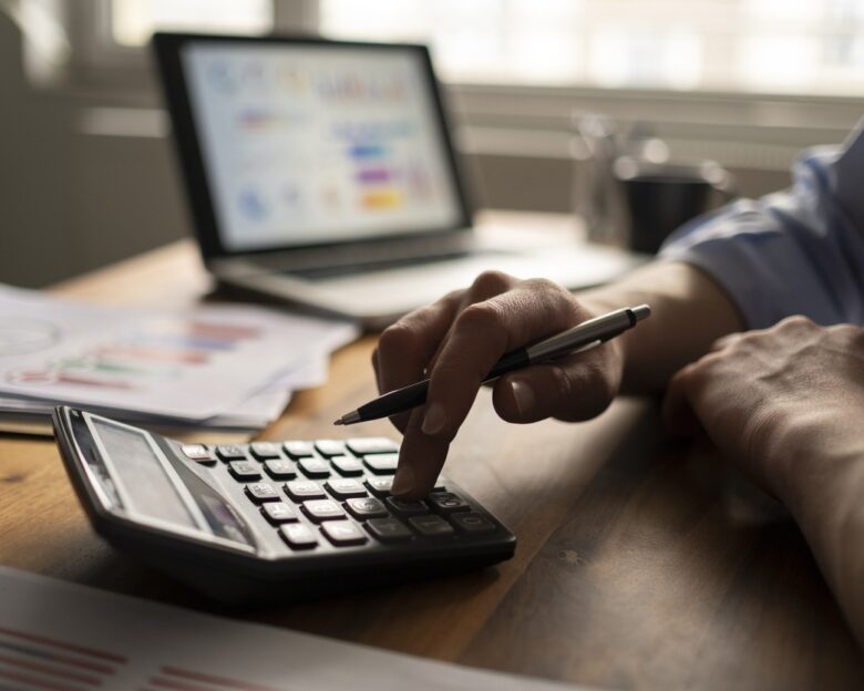 Business accounting concept, Business man using calculator with computer laptop, budget and loan paper in office.
