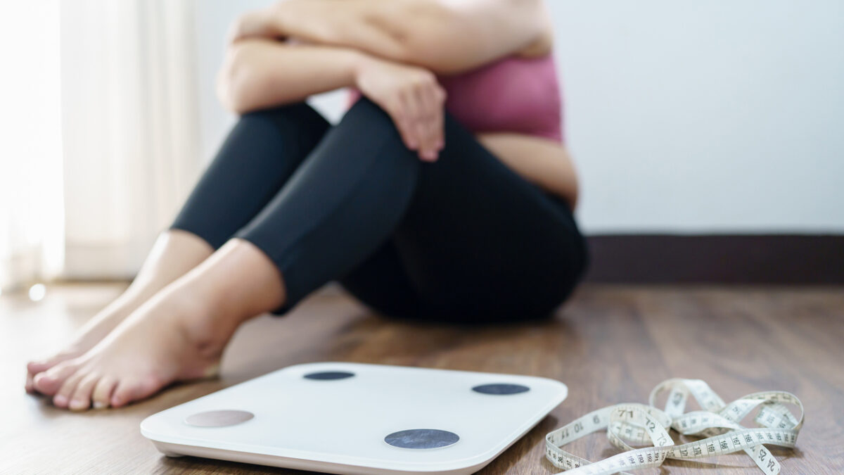 Obese Woman with fat upset bored of dieting Weight loss failÂ  Fat diet and scale sad asian woman on weight scale at home weight control