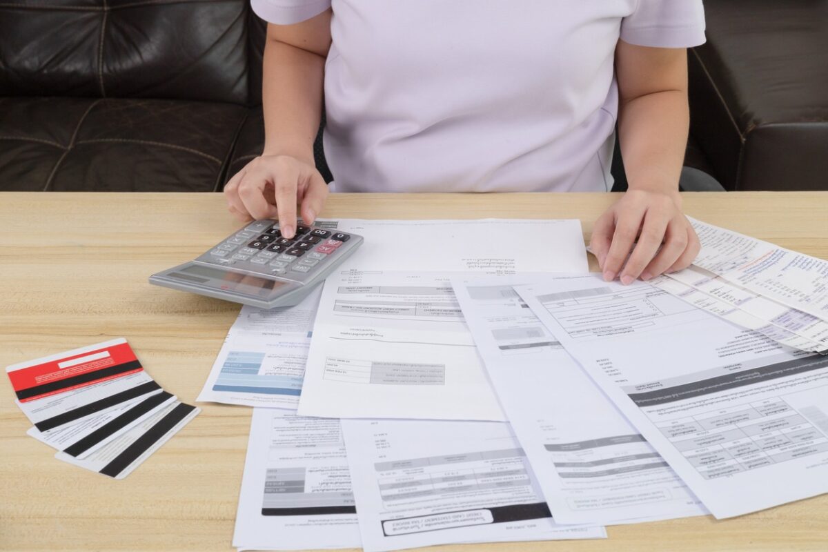 Young woman pressing the calculator for calculate the money for her dept. Asian women are stressed about payment loan problem. people with personal financial crisis concept. Debt, loan concept.