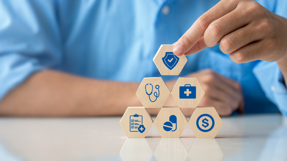 Health insurance concept. Hand holding wooden cube with healthcare medical icon. Family life insurance and policy concepts, hospital, medical treatment. copy space.