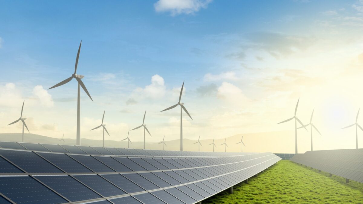 Solar farm and wind turbine on green fields