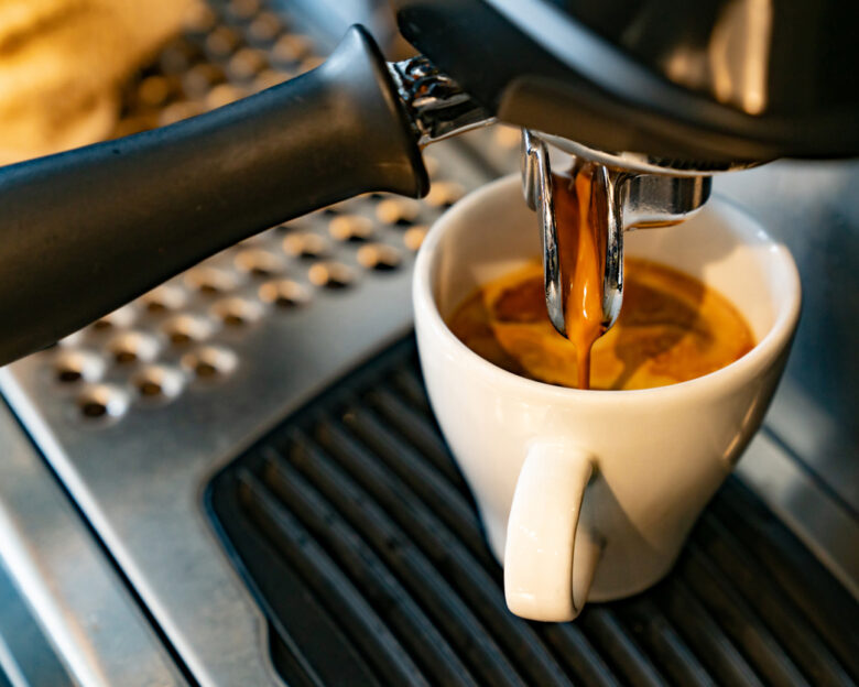 Close-up on a coffee maker making a espresso at a cafe - food and drink concepts