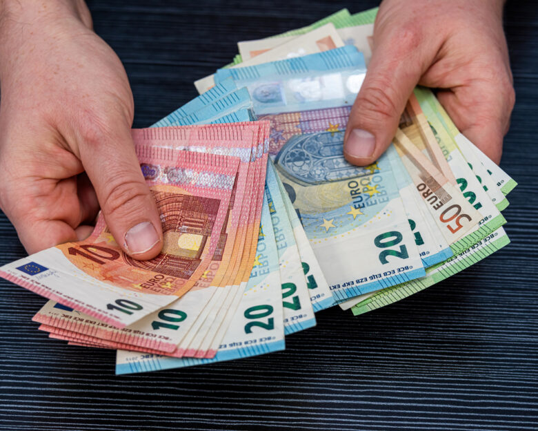 Man hold count euro money banknotes on black background. Financial concept