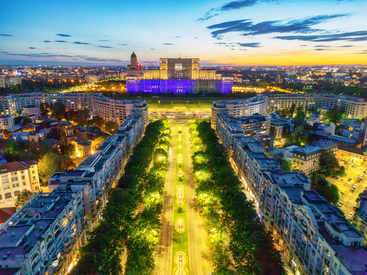 Panoramic view of downtown Bucharest at sunset, with the Palace of the Parliament in the background