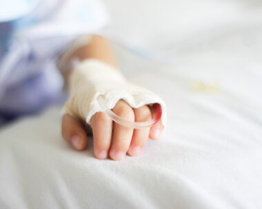 Saline intravenous (iv) drip in a Children's patient hand
