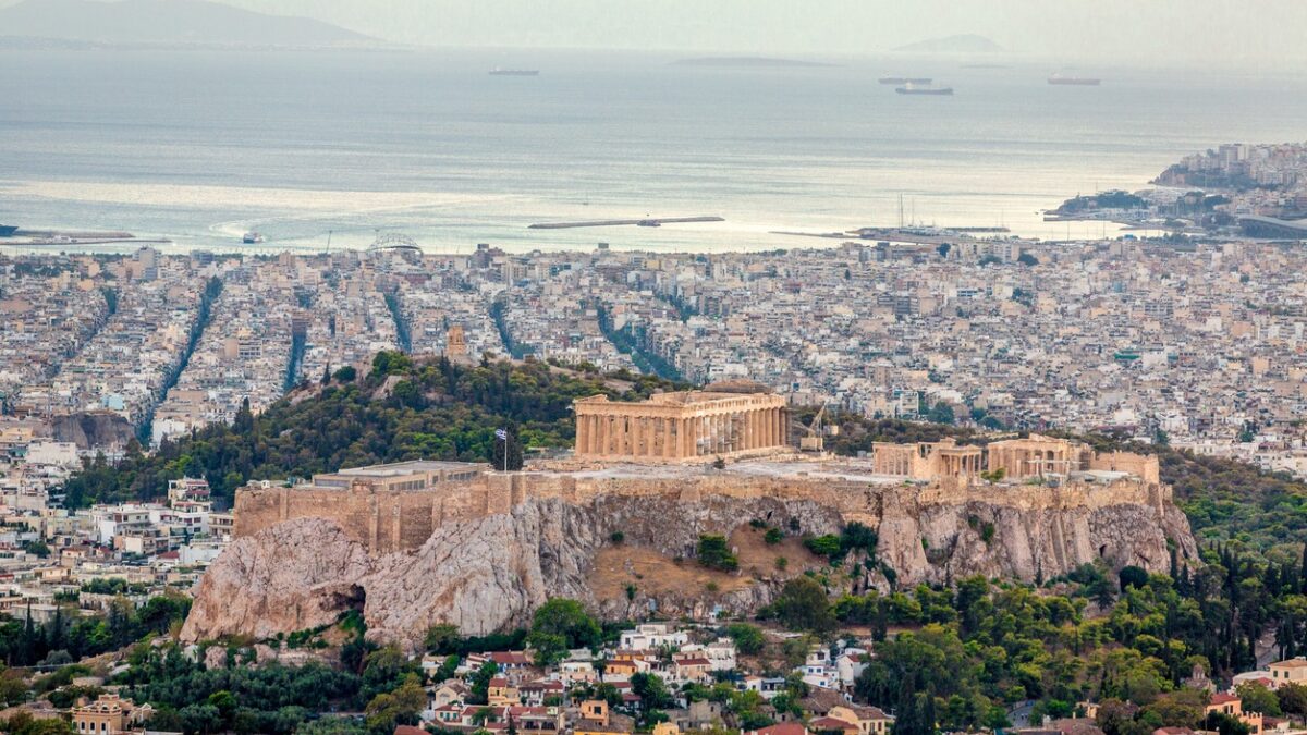 Aerial view over the city of Athens towards the mediterranean sea with the famous ancient greek Athens Acropolis in the center. Athens, Greece.