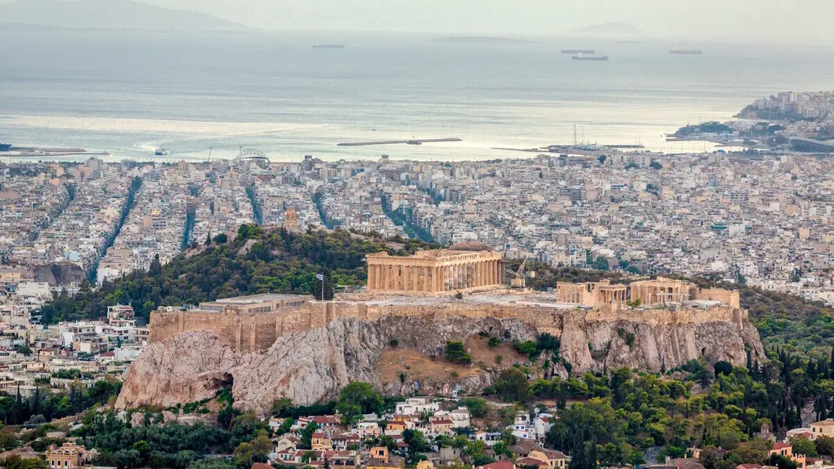 Aerial view over the city of Athens towards the mediterranean sea with the famous ancient greek Athens Acropolis in the center. Athens, Greece.
