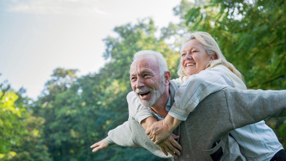 Happy senior couple smiling outdoors in nature