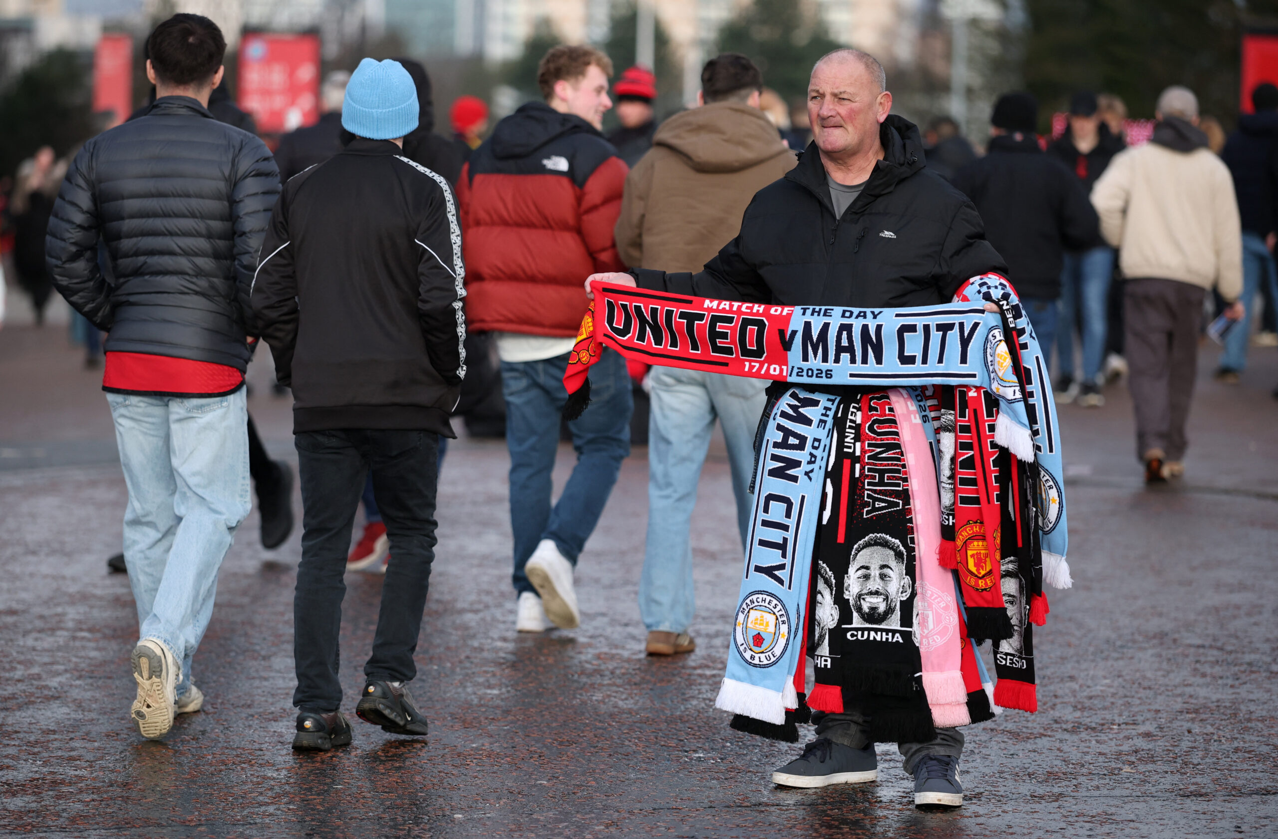 Premier League – Manchester United v Manchester City Soccer Football - Premier League - Manchester United v Manchester City - Old Trafford, Manchester, Britain - January 17, 2026 General view as a man sells Manchester United and Manchester City scarfs outside the stadium before the match REUTERS/Phil Noble EDITORIAL USE ONLY. NO USE WITH UNAUTHORIZED AUDIO, VIDEO, DATA, FIXTURE LISTS, CLUB/LEAGUE LOGOS OR 'LIVE' SERVICES. ONLINE IN-MATCH USE LIMITED TO 120 IMAGES, NO VIDEO EMULATION. NO USE IN BETTING, GAMES OR SINGLE CLUB/LEAGUE/PLAYER PUBLICATIONS. PLEASE CONTACT YOUR ACCOUNT REPRESENTATIVE FOR FURTHER DETAILS..