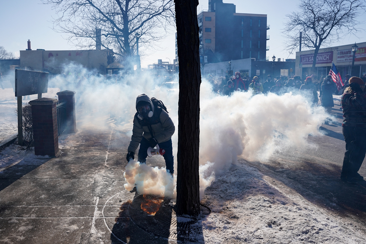 Ένα άτομο κρατάει ένα δοχείο δακρυγόνου κατά τη διάρκεια συγκρούσεων μεταξύ ομοσπονδιακών πρακτόρων και μελών της κοινότητας, στο σημείο όπου ομοσπονδιακοί πράκτορες πυροβόλησαν θανάσιμα έναν άνδρα ενώ προσπαθούσαν να τον συλλάβουν, στη Μινεάπολη