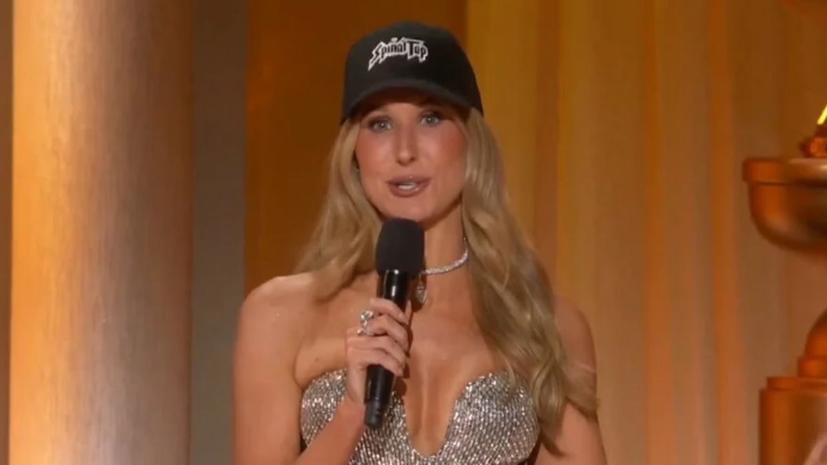 Η Νίκι Γκλέιζερ φορώντας το καπέλο με την επιγραφή Spinal Tap